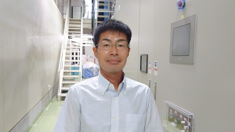 陽電子のダンピングリング電源棟内の植田猛さんの写真