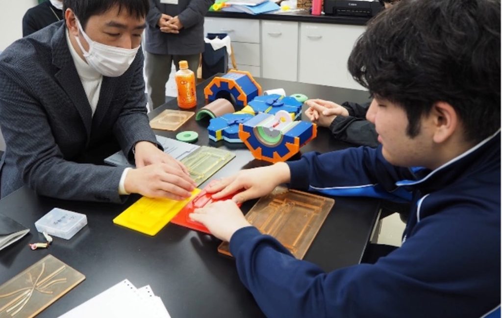 筑波大学附属視覚特別支援学校での模擬授業の様子。生徒が教材を実際に触っている。