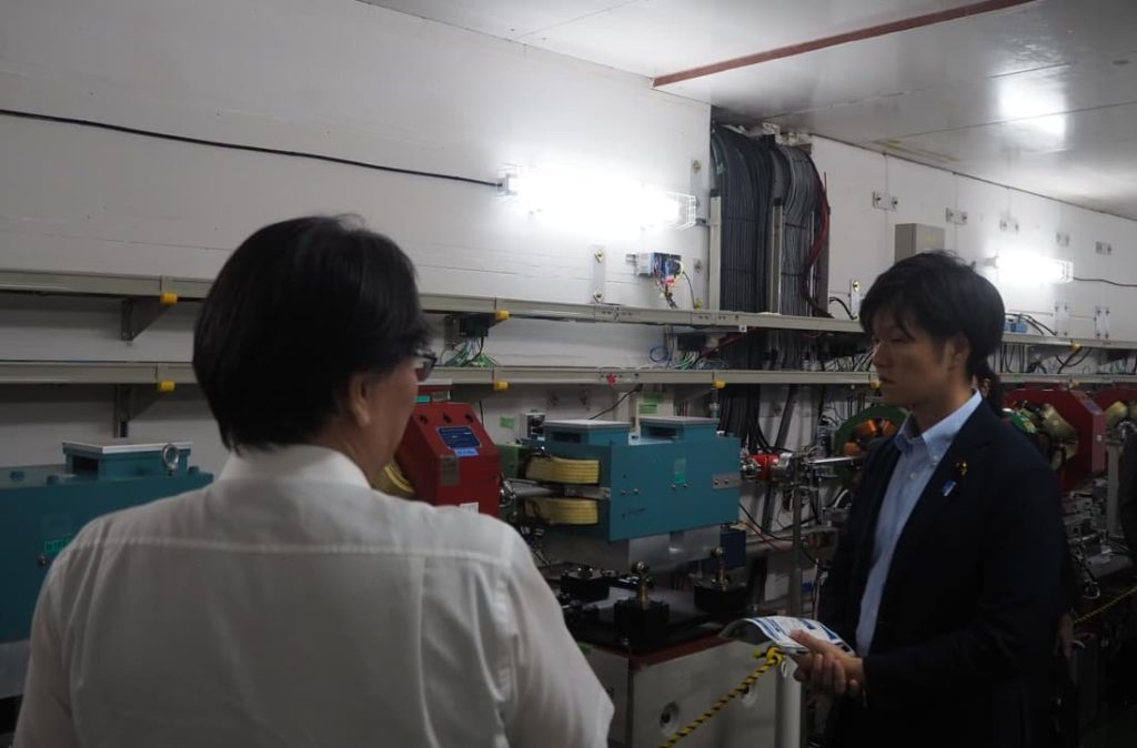 先端加速器試験施設にて研究者から説明を受ける鈴木復興副大臣（右）